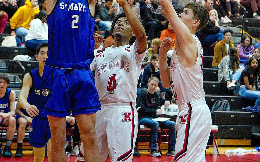 St. Mary's International's Aidan O'Flaherty shoots against Nile C. Kinnick's Darryl Williams and Ethan Yuska during Tuesday's Kanto Plain boys basketball game. The Titans won 74-54.