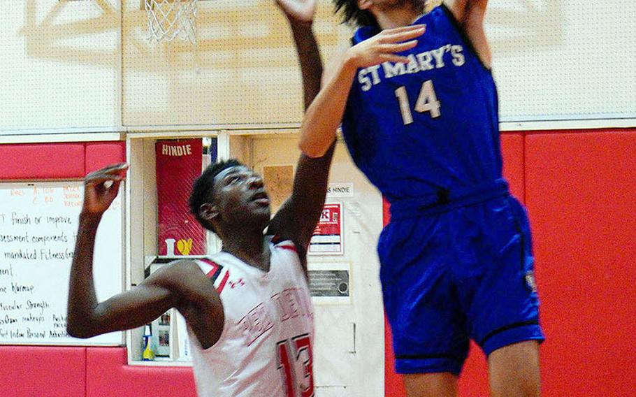 St. Mary's Alister Jones drives for a layup past Nile C. Kinnick's Corey Hollingsworth during Tuesday's Kanto Plain boys basketball game. The Titans won 74-54.