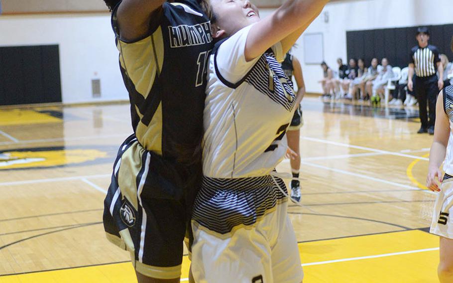 Humphreys' Acacia May leaps over the back of Taejon Christian's Minha Choi for a rebound during Wednesday's Korea Blue girls basketball game. The Blackhawks won 44-17.