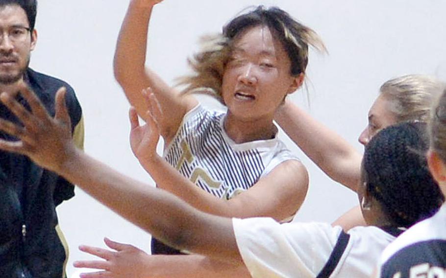 Taejon Christian's Kunlan Yang saves the ball from going out of bounds against Osan during Tuesday's Korea Blue girls basketball game. Yang had 25 points, including the first 21 scored by TCIS, as the Dragons won 34-30.