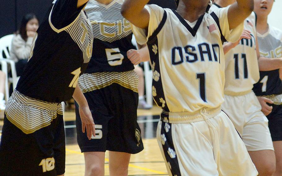 Osan's Tailan Hickey puts up a shot past Taejon Christian's Sylvia Yun during Tuesday's Korea Blue girls basketball game. The Dragons won 34-30.