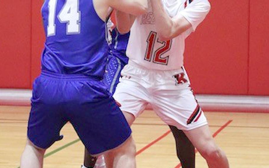 Nile C. Kinnick's Ethan Yuska fights for the ball with Christian Academy Japan's Leif Matsumoto during Friday's Kanto Plain boys basketball game. The Knights won 68-64.