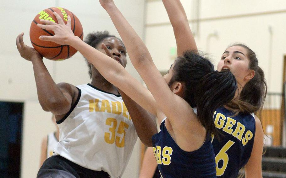 Kadena's Alexis Boyer has her shot blocked by Taipei American defenders during Saturday's Taipei Basketball Exchange girls game. The Tigers routed the Panthers 61-35.