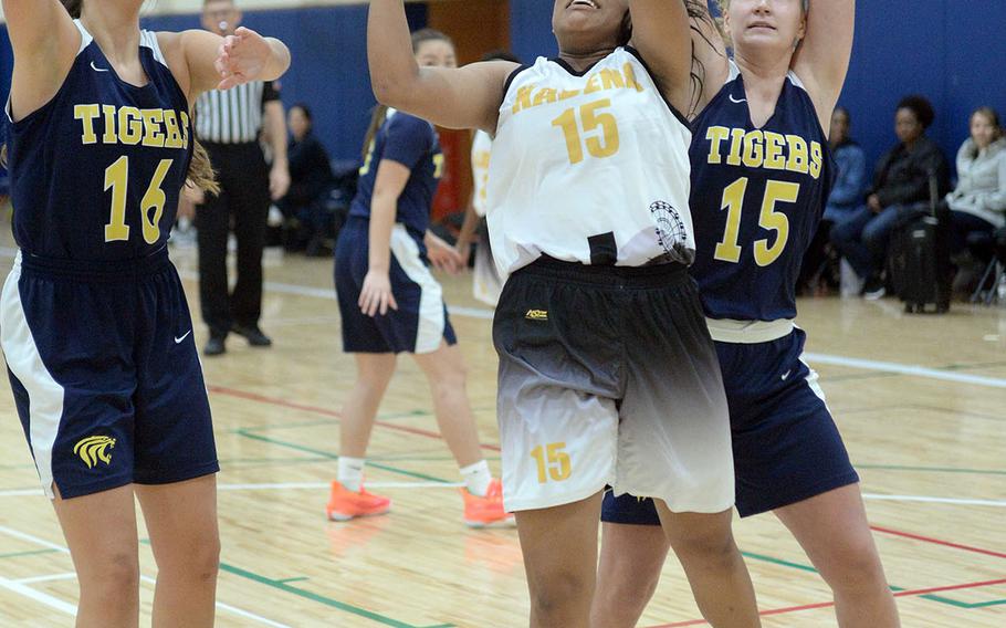 Kadena's Kyleigh Wright shoots between Taipei American defenders during Saturday's Taipei Basketball Exchange girls game. The Tigers routed the Panthers 61-35.