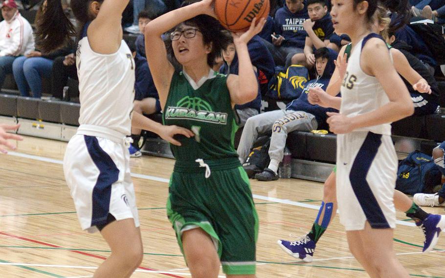 Kubasaki's Urara Williams drives between Taipei American defenders during Saturday's Taipei Basketballl Exchange girls game. The Dragons lost 50-27.