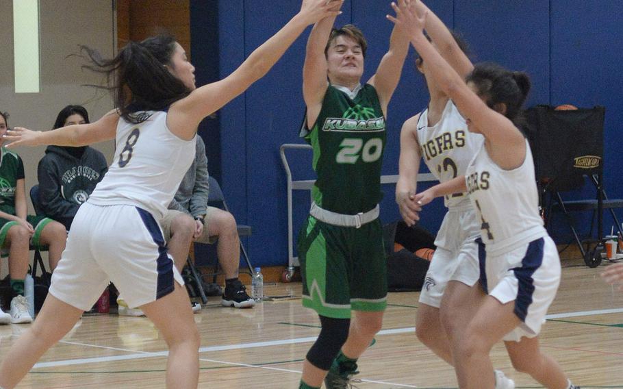 Kubasaki's Ari Gieseck fights between Taipei American defenders for the ball during Saturday's Taipei Basketballl Exchange girls game. The Dragons lost 50-27.