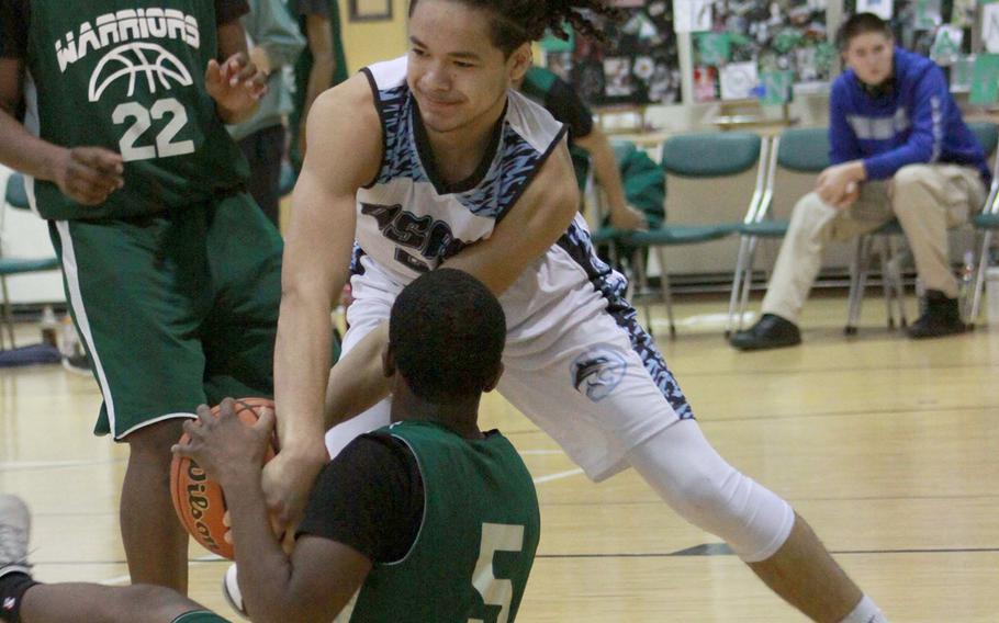 Osan's Israel Rouse and Daegu's Andrue McCall scuffle for the ball as Warriors teammate Antwoine McCall watches during Saturday's Korea Blue boys basketball game. The Cougars won 56-31.