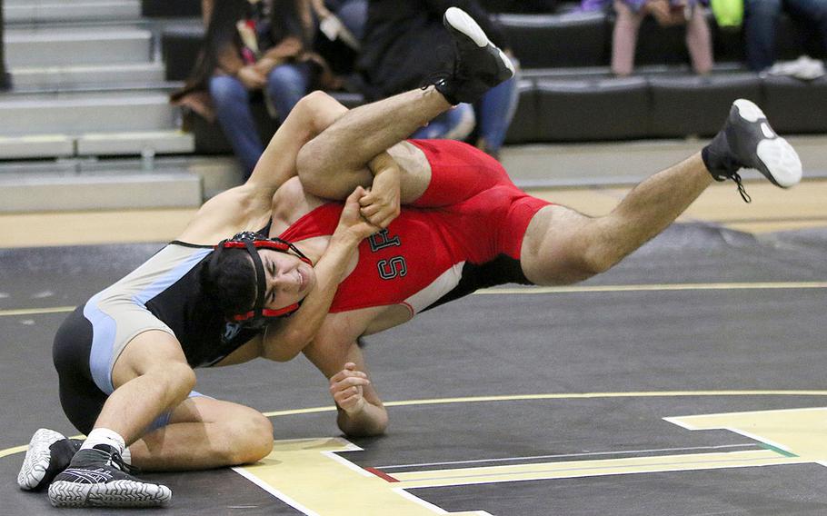 Seoul Foreign's Jacob Kazem is sent airborne by Osan's Marcus Inthavixay at 168 pounds during Saturday's dual meet at Humphreys. Inthavixay won by pin and the Cougars won the dual meet 37-21.