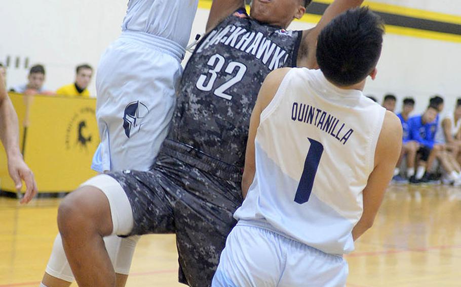 Humphreys' Donovan Okpokwasili gets sandwiched by two St. Paul Christian defenders during Thursday's ASIJ Kanto Classic boys game. The Warriors stunned the defending champion Blackhawks 36-35 in the tournament opener.