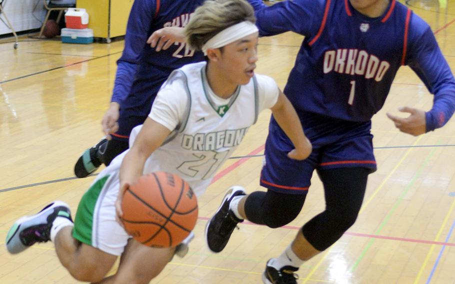 Kubasaki's Dylan Canlas drives around Okkodo defenders during Thursday's ASIJ Kanto Classic boys game. The Bulldogs routed the Dragons 72-51.