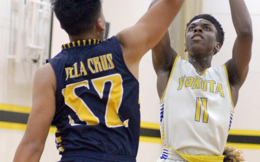 Yokota's Marcus Berrette shoots over Guam High's Damien Dela Cruz during Thursday's ASIJ Kanto Classic boys game. Yokota won 47-43.
