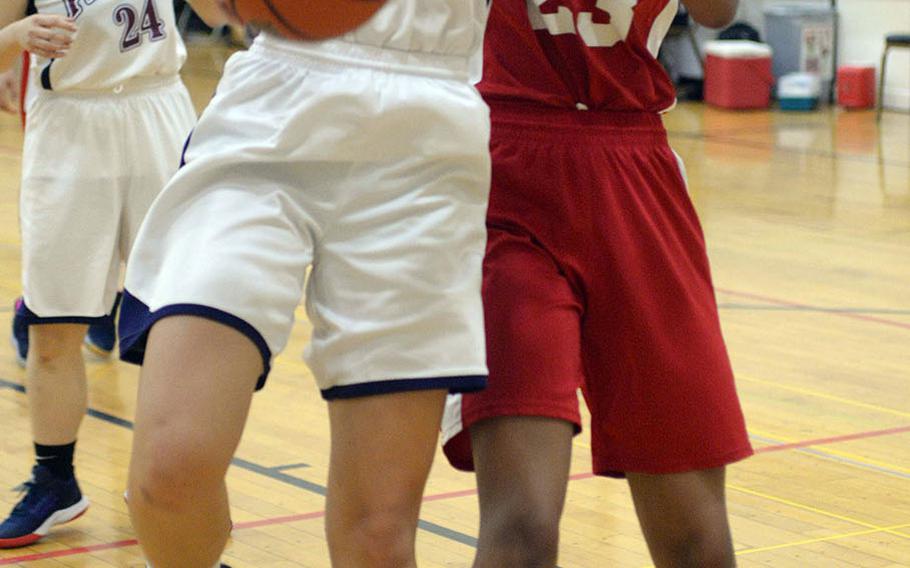 Seisen's Lisa Purcell snags a rebound in front of Nile C. Kinnick's Dana White during Thursday's ASIJ Kanto Classic girls game. The Red Devils won 31-26.