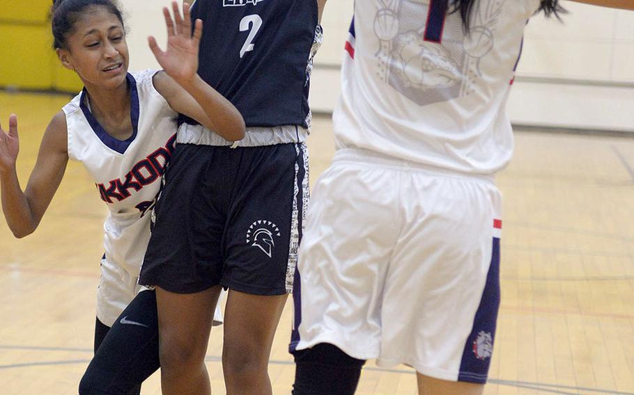 Zama's Chloe Sterling shoots between Okkodo defenders during Friday's ASIJ Kanto Classic girls game. The defending Far East Division II champion Trojans edged the Bulldogs 52-50.