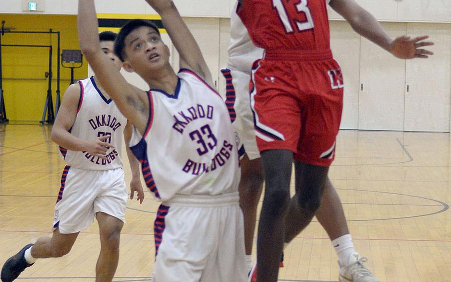 Nile C. Kinnick's Corey Hollingsworth tries to shoot between Okkodo defenders during Friday's ASIJ Kanto Classis boys game. The Red Devils won 57-50.