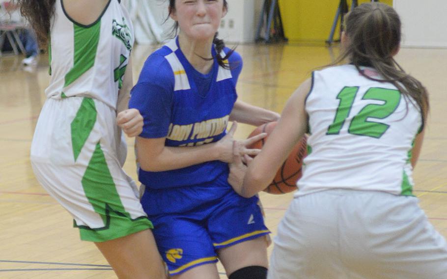 Yokota's Emily Taynton tries to drive between Kubasaki's Sophia Grubbs and Racquelle Kilian during Friday's ASIJ Kanto Classic girls game. The Panthers won 34-27.