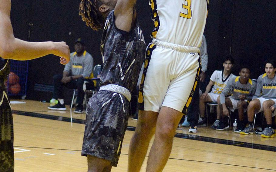 Kadena's Casey Cox shoots over Humphreys' Junior Gregory during Friday's ASIJ Kanto Classic boys game. In what many observers called a possible championship game preview, the defending champion Blackhawks edged the Panthers 49-46.