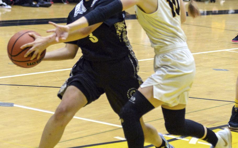 American School In Japan's Cora Eaton reaches in to slow down Zama's Kirari Smith during Saturday's girls varsity basketball finals game. Zama won the game and the tournament championship.