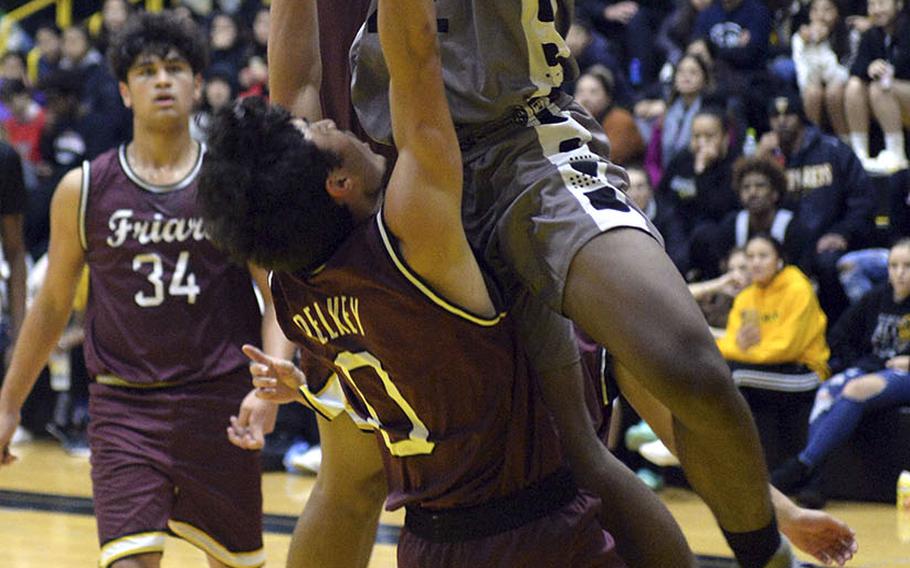 Kadena's John Emery III plows into Father Duenas' Isaiah Pelkey during Saturday's boys varsity finals game. An offensive foul was called on the play. In the end, Father Duenas won the game and the tournament championship.