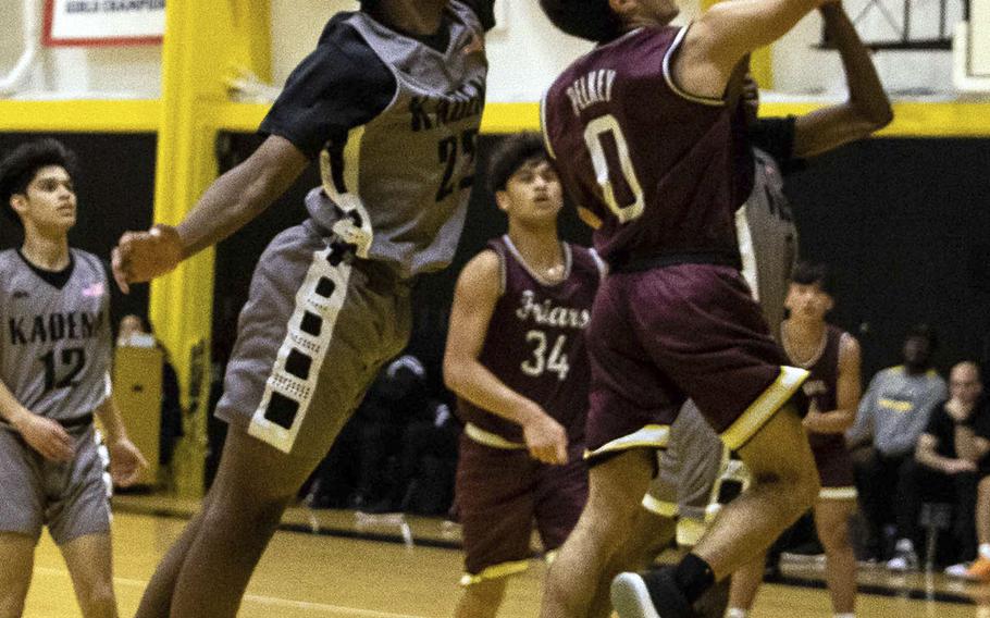 Father Duenas' Isaiah Pelkey shoots past Kadena's John Emery III during Saturday's boys varsity basketball finals game. Father Duenas won the game and the tournament championship.