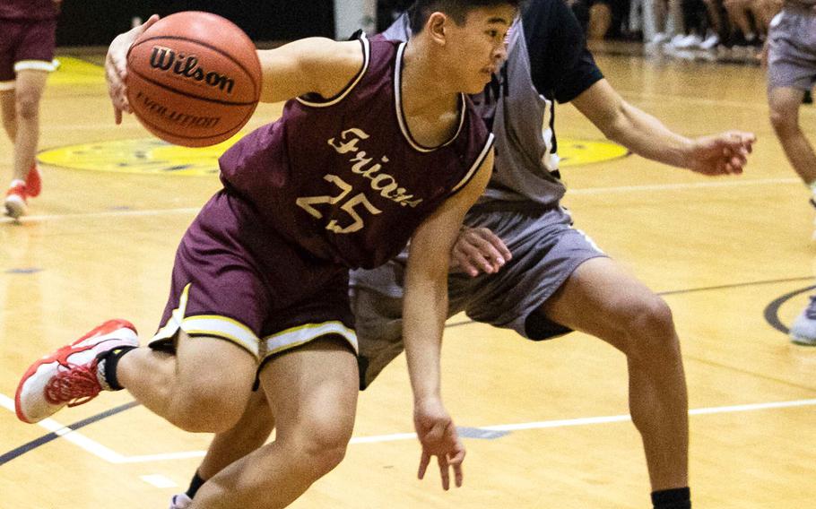 Father Duenas' Matthew Santos dribbles against Kadena's Tristan Higginson during Saturday's boys varsity basketball finals game. Father Duenas won the game and the tournament championship.