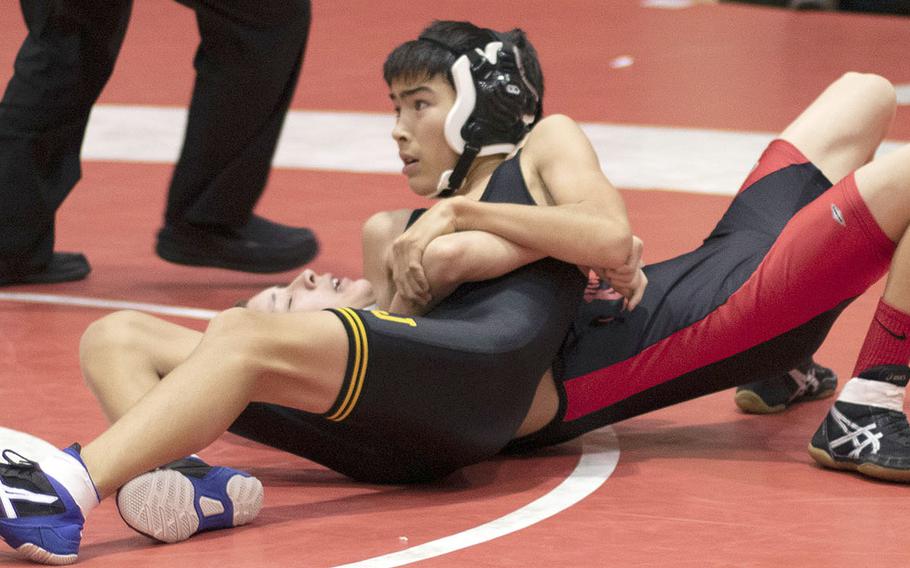 American School In Japan's Kaisei Smith tries to finish off Nile C. Kinnick's D.J. Hurtado at 101 pounds during Wednesday's Kanto Plain dual meet. Smith won by pin in 1 minute and the Mustangs won the meet 34-22.