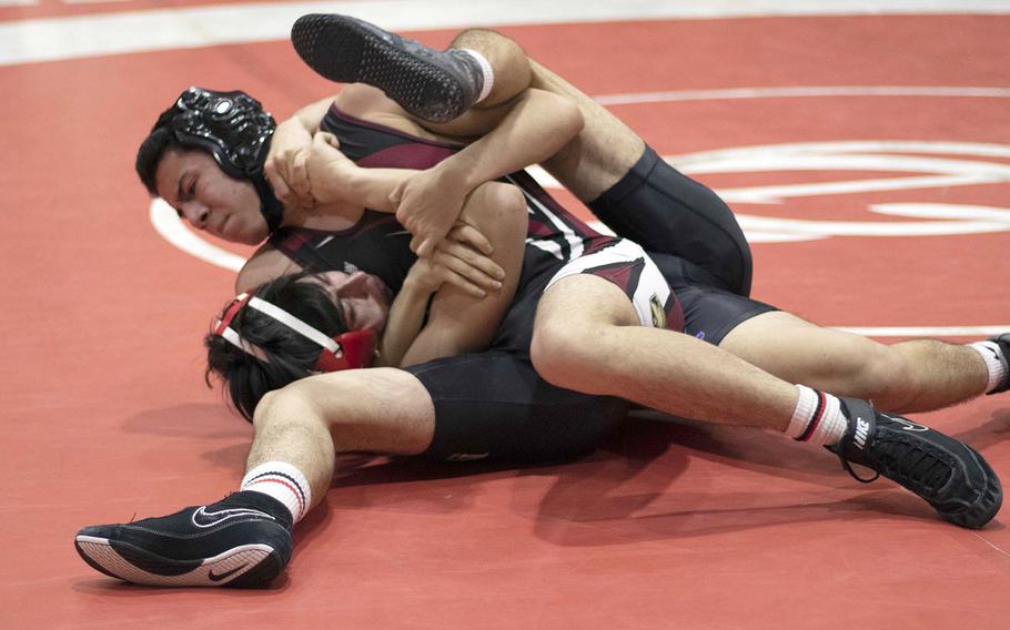 Zama's Moises Caravajal gets a head-and-arm hold on Nile C. Kinnick's Justin Rose at 129 pounds during Wednesday's Kanto Plain dual meet. Caravajal pinned Rose in 1 minute, 25 seconds, but the Red Devils won the meet 47-14.
