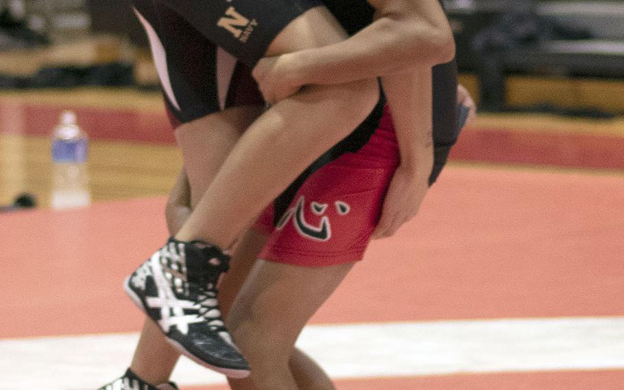 Nile C. Kinnick's Michael Lozano lifts Zama's Cruzy Cruz at 108 pounds during Wednesday's Kanto Plain dual meet. Leon Guerrero won by pin in 50 seconds and the Red Devils won the meet 47-14.