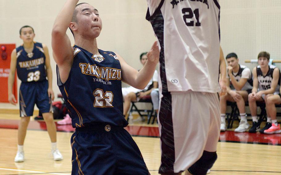 Matthew C. Perry's Joseph Andres shoot past an Iwakuni Takamizu defender during Wednesday's Japan boys basketball game. The Samurai won 77-70.