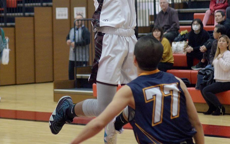 Matthew C. Perry's Shion Fleming shoots over an Iwakuni Takamizu defender during Wednesday's Japan boys basketball game. The Samurai won 77-70.