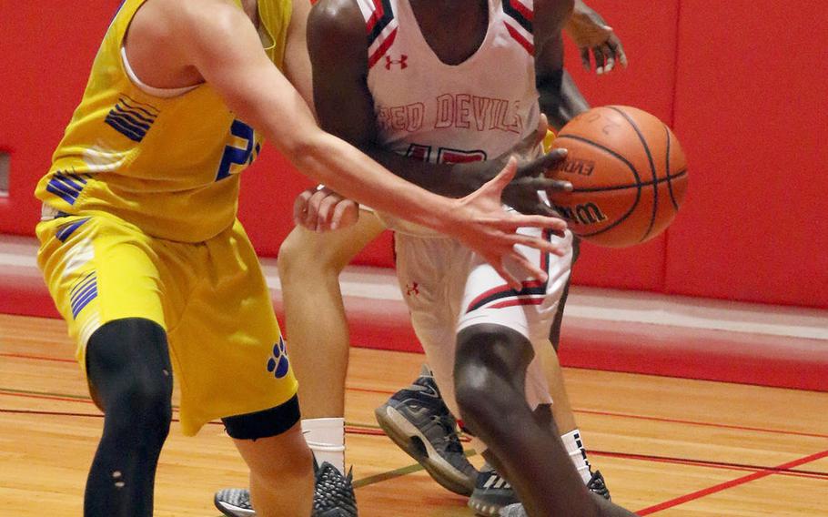 Nile C. Kinnick's Corey Hollingsworth drives on Yokota's Connor Rowan during Tuesday's DODEA-Japan/Kanto Plain boys basketball game. The Red Devils won 57-55.