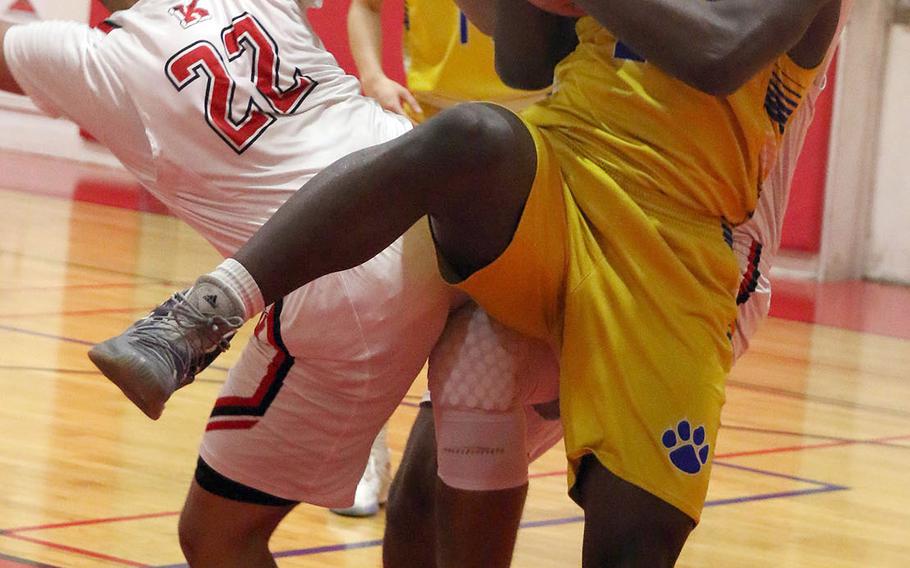 Nile C. Kinnick's Yuri Delacruz and Yokota's C.J. Canada struggle for the ball during Tuesday's DODEA-Japan/Kanto Plain boys basketball game. The Red Devils edged the Panthers 57-55.
