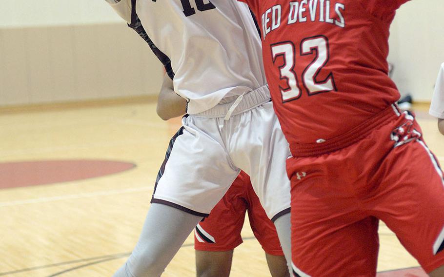 Matthew C. Perry's Shion Fleming and Nile C. Kinnick's Marcellus Harris scuffle for a rebound during Friday's DODEA-Japan boys basketball game. The Red Devils won 62-39,