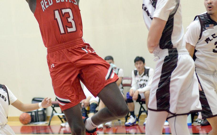 Nile C. Kinnick's Corey Hollingsworth shoots past Matthew C. Perry's Dylan Schuch during Friday's DODEA-Japan boys basketball game. The Red Devils won 62-39,