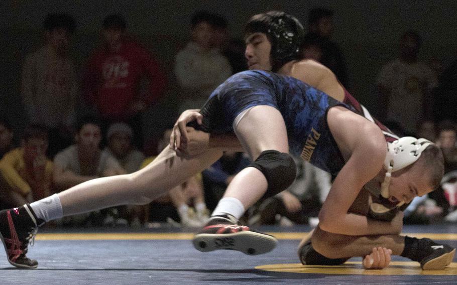 Yokota's Caleb Heino works his way to a 10-0 technical-fall victory over Zama's Kaito Hayashi to win the 122-pound title in the Kanto finals.