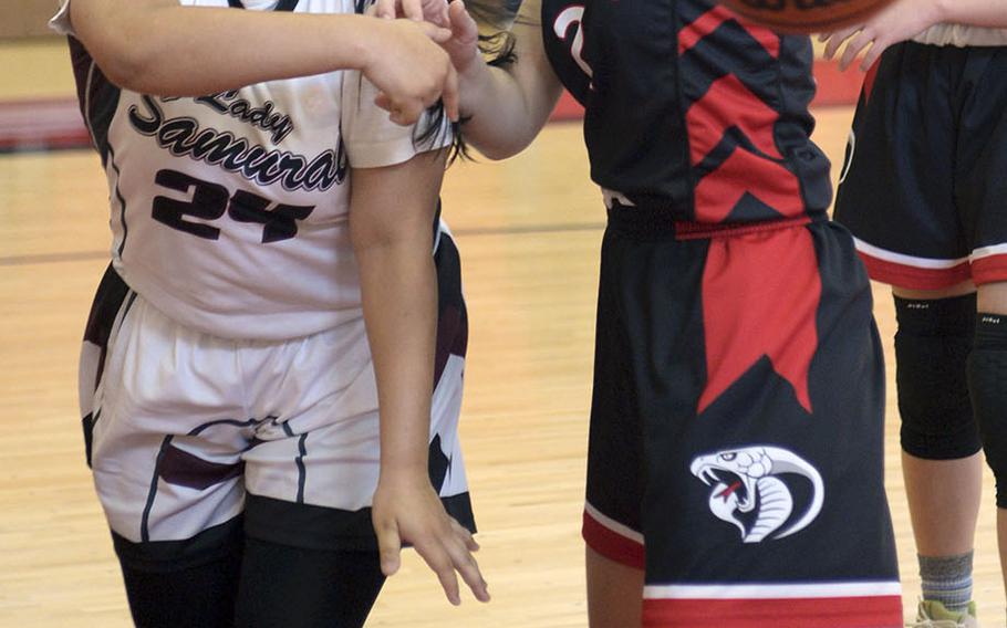 Matthew C. Perry's Hokulani Gleason tosses the ball past E.J. King's Aileen Fitzgerald during Saturday's DODEA-Japan girls basketball game. The Cobras won 61-36.