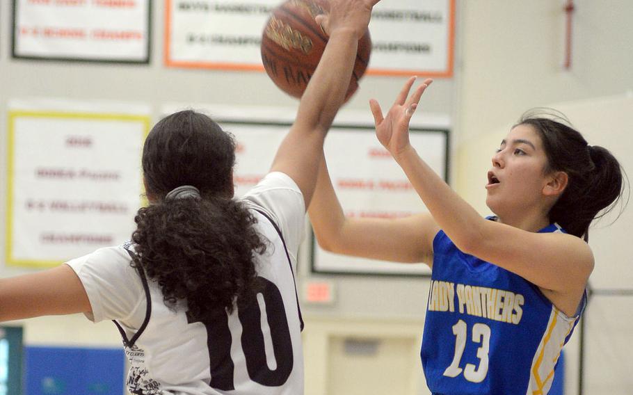 Yokota's Keiya Carlson shoots against Zama's Fabiola Ayala-Rivera during Friday's DODEA-Japan girls semifinal, won by the Trojans 68-37.