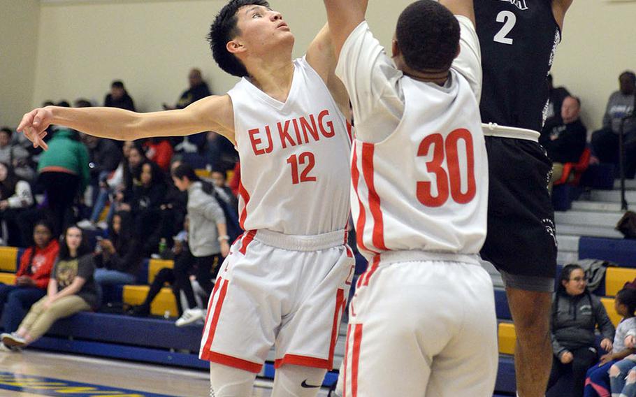 Zama's Kalil Irby shoots over E.J. King's Marcus Schrader and Jalen Nall during Friday's DODEA-Japan boys semifinal, won by the Trojans 62-53.