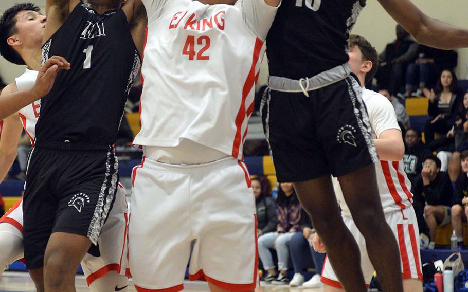 Zama's Keshawn McNeill and Chandler Platt sandwich E.J. King's Tsuyoshi Kemp going for a rebound during Friday's DODEA-Japan boys semifinal, won by the Trojans 62-53.