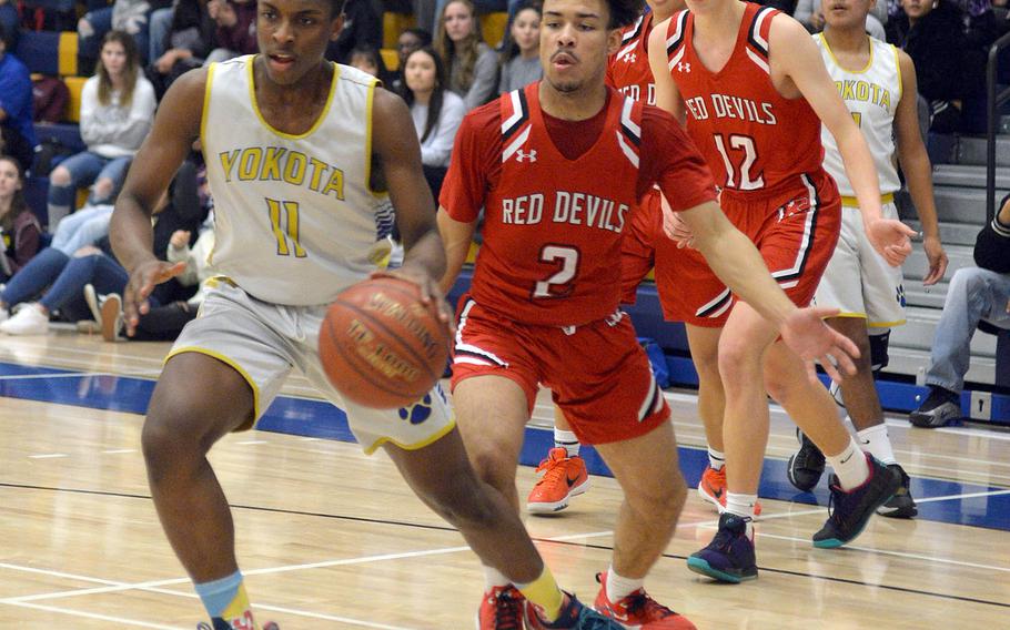 Yokota's Marcus Berrette heads to the basket with Nile C. Kinnick's James Mincey, Ethan Yuska and Tristan Venturina in trail during Friday's DODEA-Japan boys semifinal, won by the Red Devils 68-64.