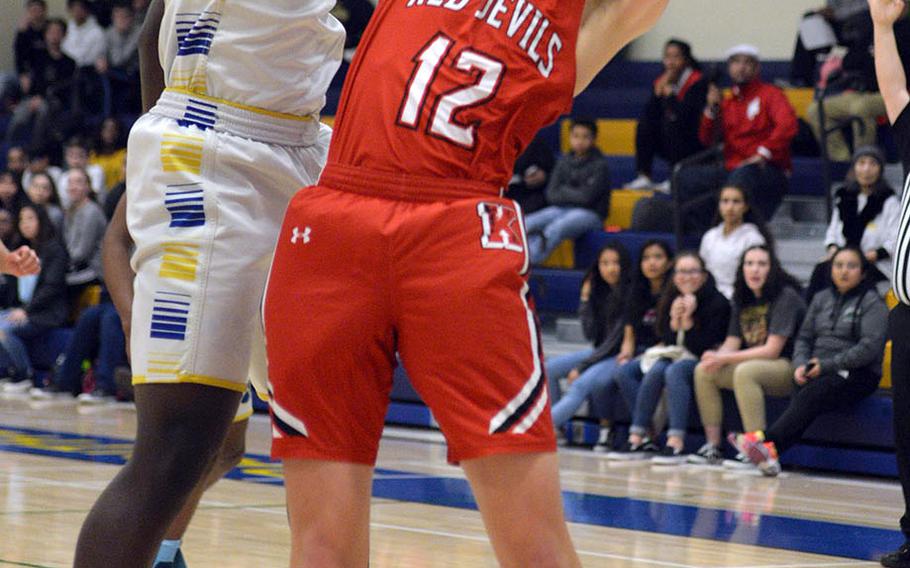 Yokota's C.J. Canada slaps the ball away from Nile C. Kinnick's Ethan Yuska during Friday's DODEA-Japan boys semifinal, won by the Red Devils 68-64.