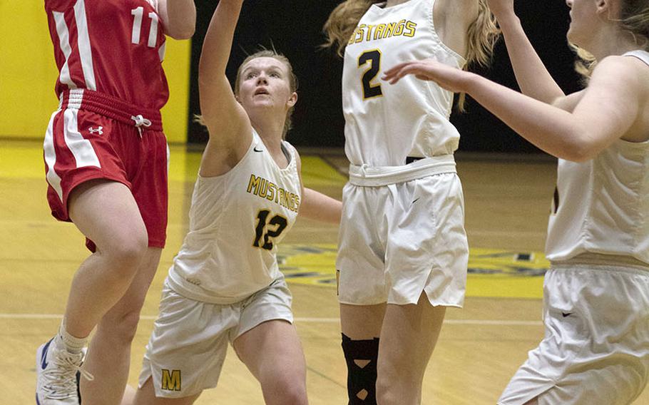 Nile C. Kinnick's Cassi Boyer shoots against American School In Japan's Maja Greenqvist, Pari Eaton and Jessica Sliter during Tuesday's Kanto Plain girls basketball game. The Mustangs won 36-20.