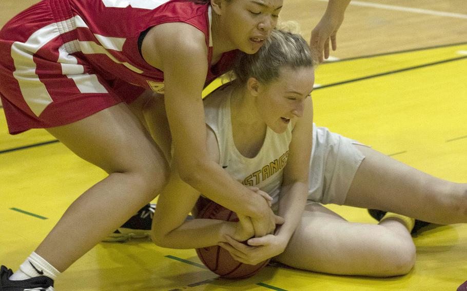 Nile C. Kinnick's Amyka Jones and American School In Japan's Jessica Sliter battle for the ball during Tuesday's Kanto Plain girls basketball game. The Mustangs won 36-20.