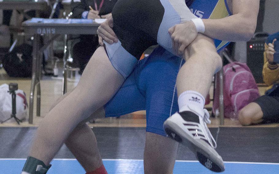 St. Mary's Hikaru Shimada tries to lift Osan's Toy Williams in the 141-pound Far East final. Shimada won by technical fall 10-0.