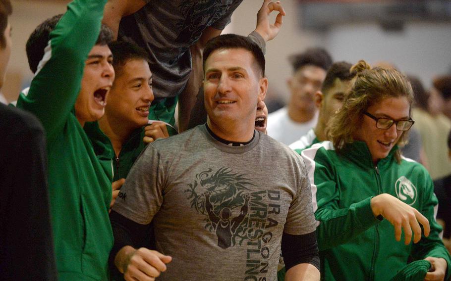 Kubasaki coach Brent Cook and his Dragons celebrate their repeat Far East Division I individual freestyle team title.