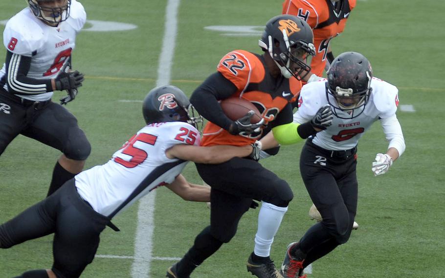 Hansen running back Deirre Lismon tries to elude Ryudai defenders Hiroya Tanaka, Takasuke Kushima and Yuise Shimabukuro.