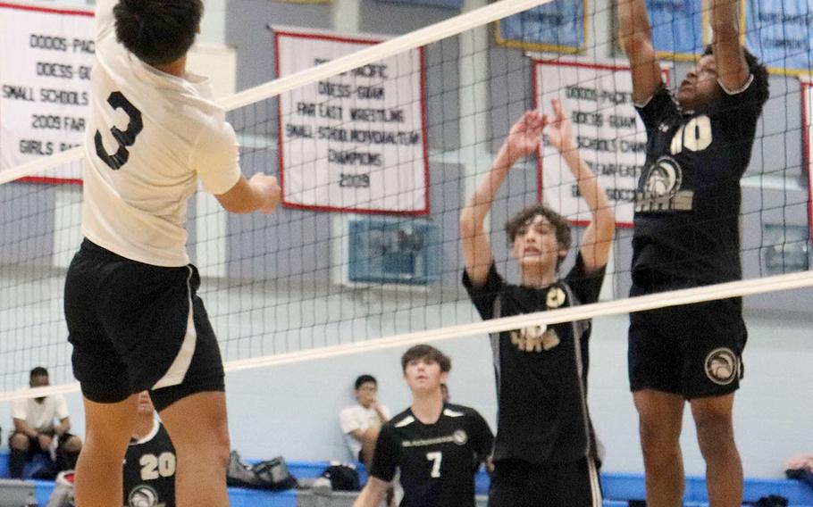 Osan's Anthony Panboon lines up a spike against Humphreys Black's JaKadric Thomas and John Matlock during Wednesday's Korea volleyball. The Cougars won 25-15, 25-12.