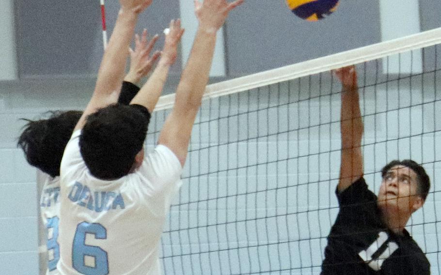 Daegu's Troy Charley tries to hit past Osan's Tim Petrae and Sergio DeLuca during Friday's Korea boys volleyball match. The Cougars beat the Warriors 26-24, 25-16.