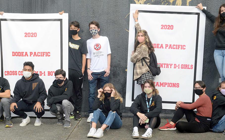 Kadena's cross country teams gather 'round the Far East Division team banners.