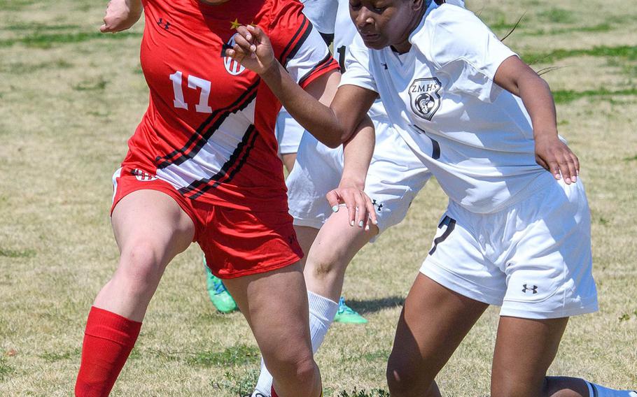 Nile C. Kinnick's Charley Lau and Zama's Makyah Sanders-Vaughn scuffle for the ball in Saturday's battle of reigning Far East girls soccer tournamernt champions. The Division I Red Devils blanked the Division II Trojans 6-0.
