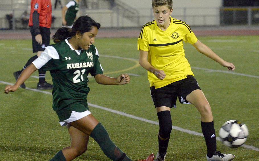 Kubasaki's Nicole Fuentes boots the ball past Kadena's Michelle Sawyer during Friday's Okinawa girls soccer match. The Panthers won 3-0.